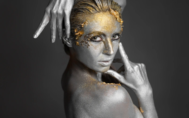 fine art portrait photography of a woman covered in silver and golden body paint