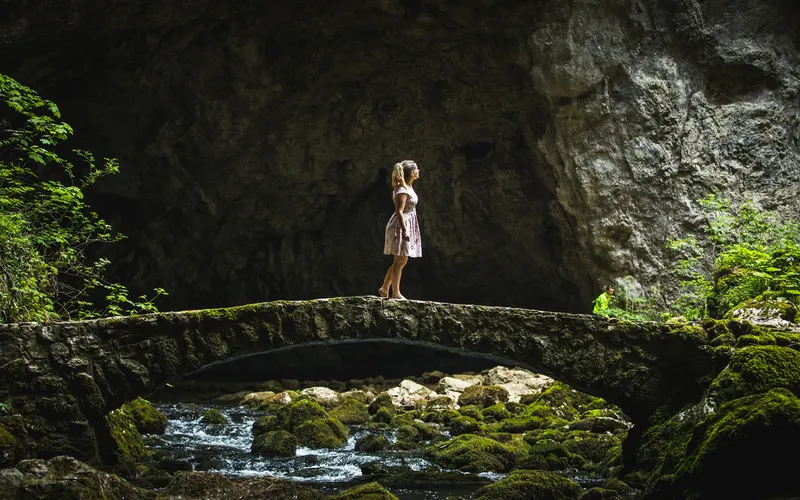 Model posing inside a cave for dramatic human figure poses.