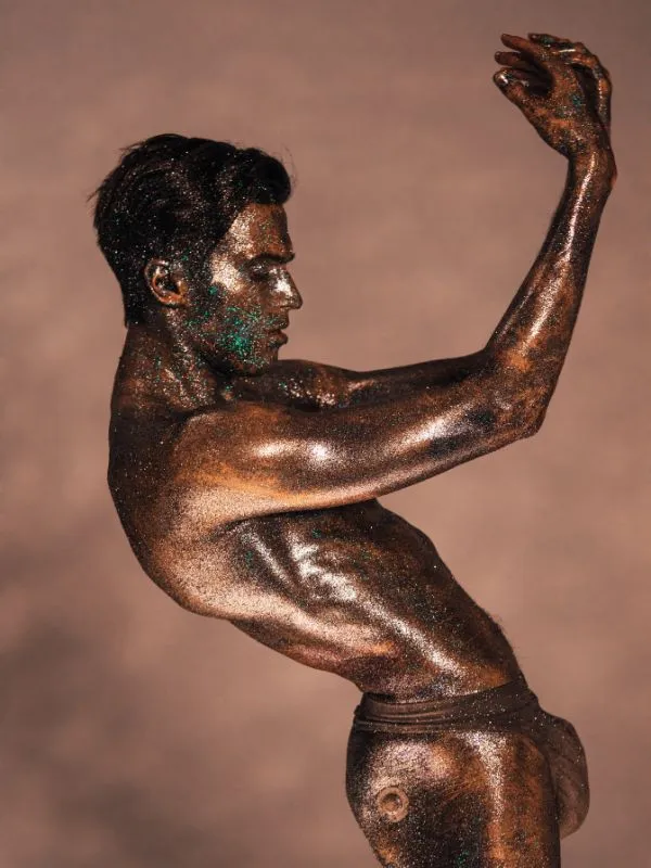 a man posing covered in glitter