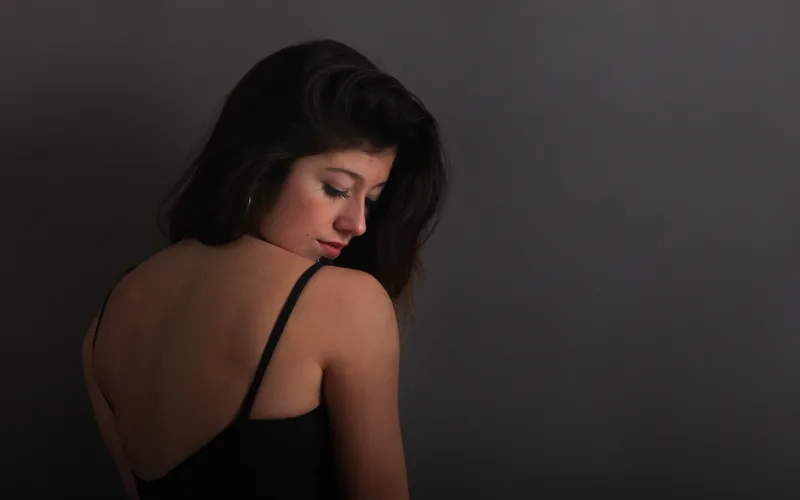Silhouette of a model in profile, showing how implied lines photography uses light and shadow to define the body's contours
