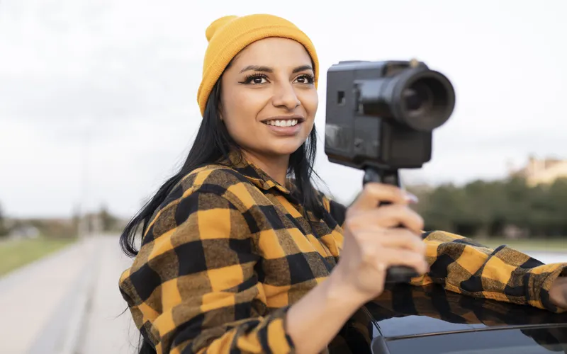 women taking videos through her camera from a moving car