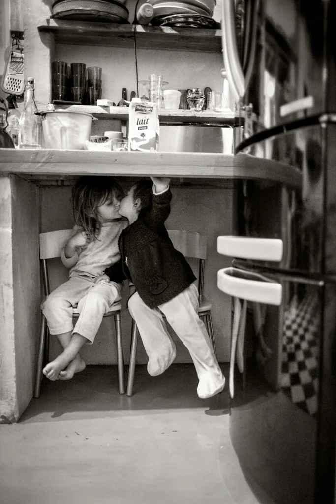 black and white image of kids kissing