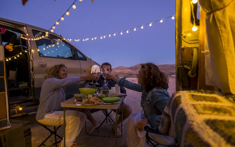 friends enjoying near camper van