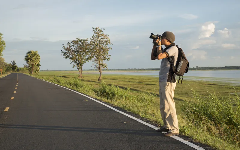 photographer taking pictures by a rural road