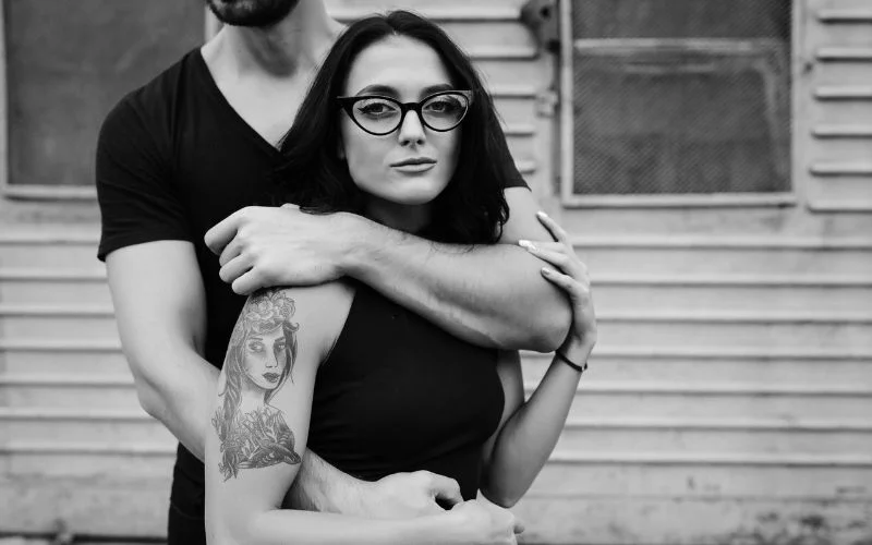 Black and white close-up of a woman gently holding her partner's arm