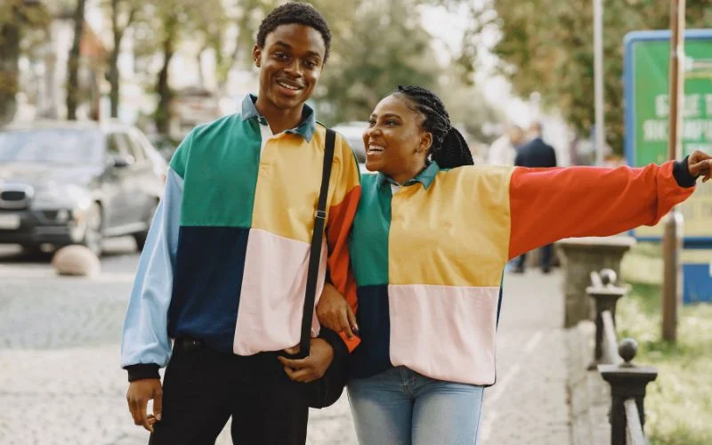 Couple in color-blocked coordinating outfits walking together on a city street