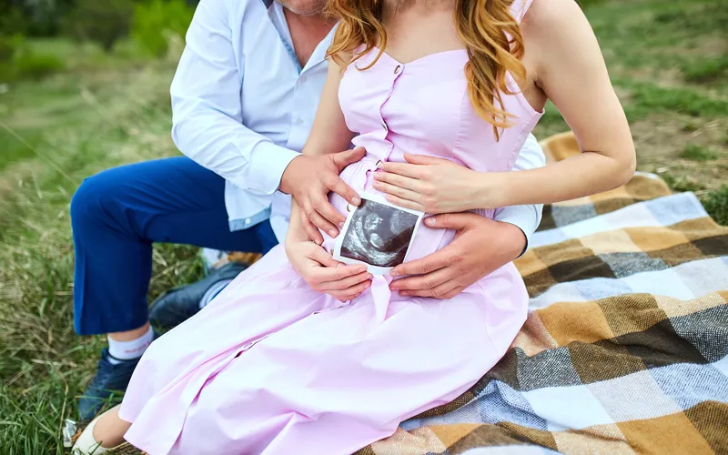 women and man holding sonogram