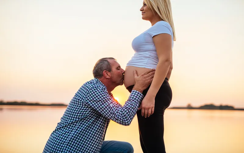 pregnancy photoshoot poses of man kissing the tummy