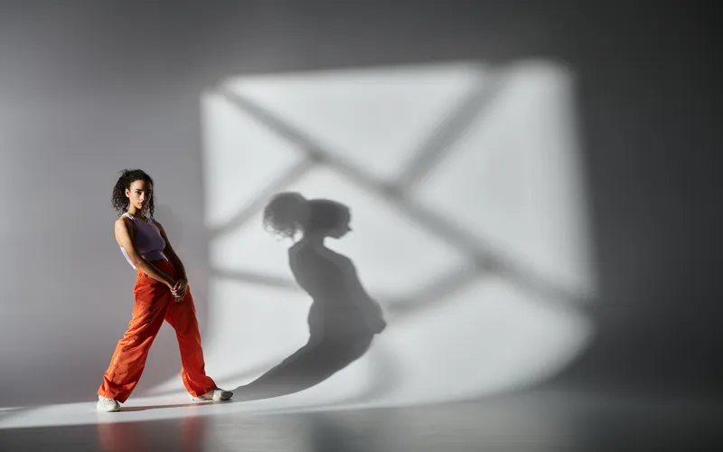 woman posing in orange pants with shadows