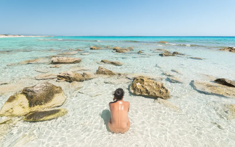 a woman sitting in water on beach