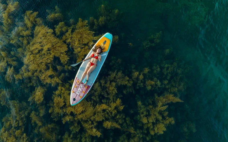 nude beach poses - woman on a surfboard
