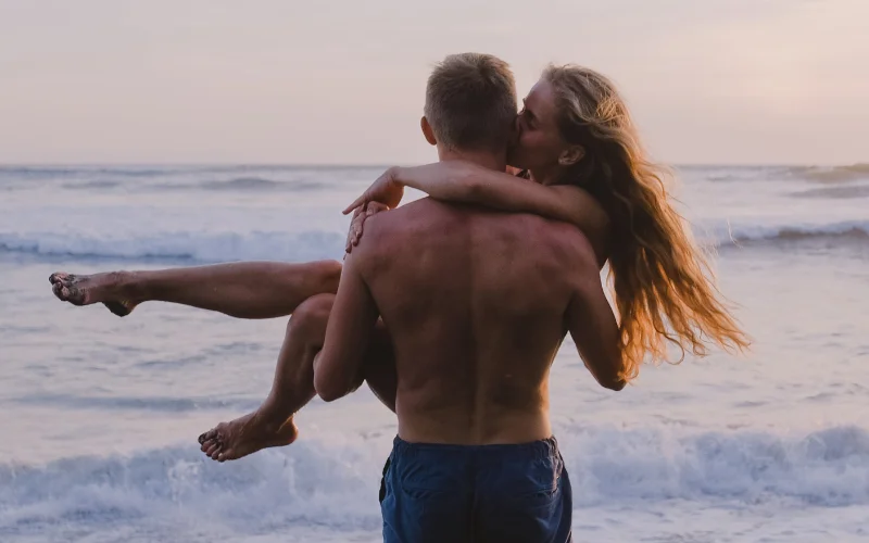 nude couple posing on the beach