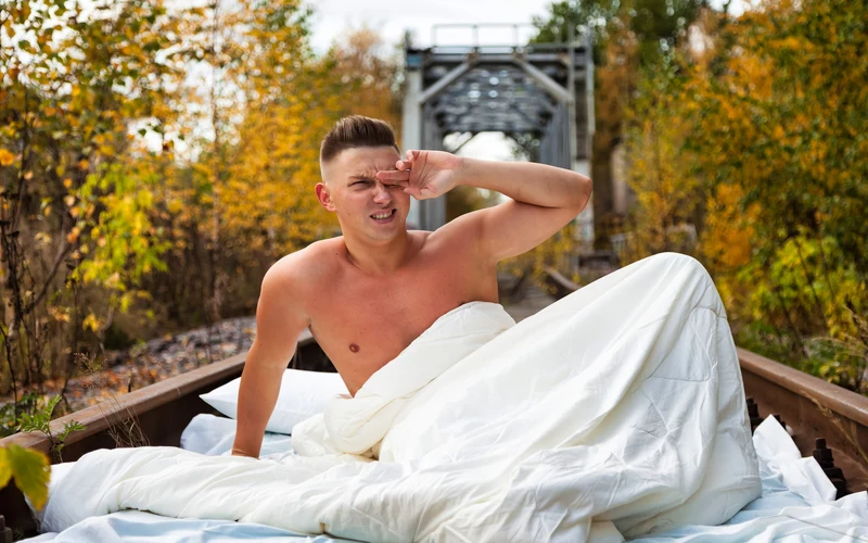 Young man waking up outdoors
