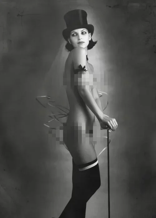 naked model with a hat and holding stick in her hand