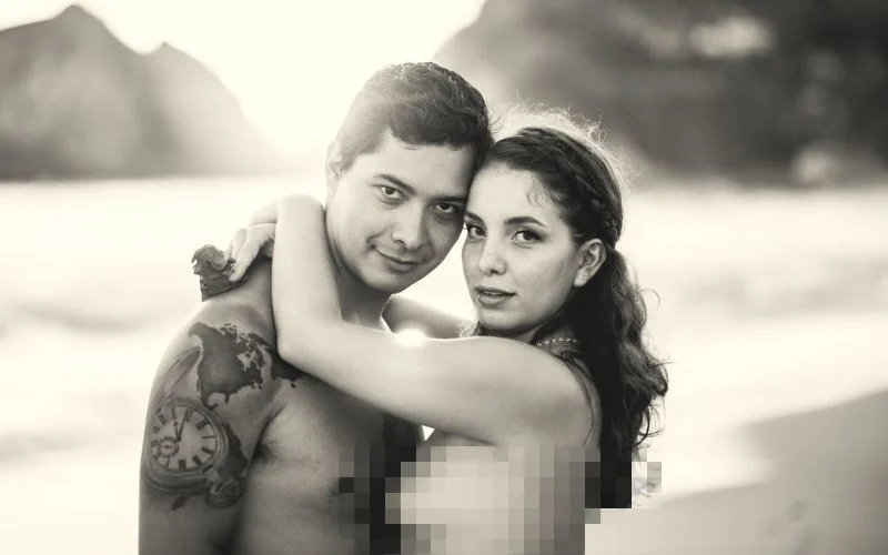 black and white image of a naked couple on a beach