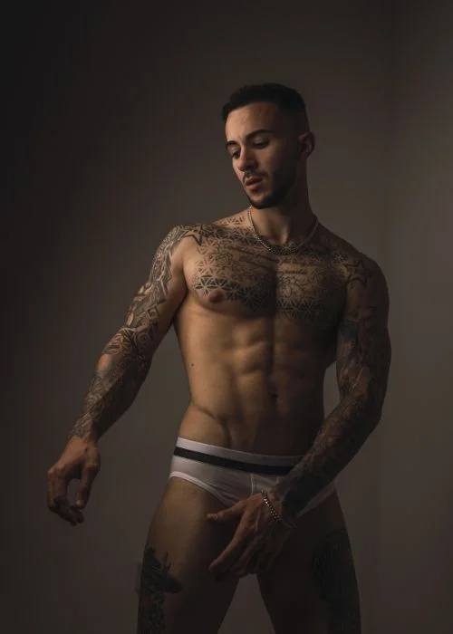 Confident men boudoir pose with dramatic lighting and relaxed masculine expression