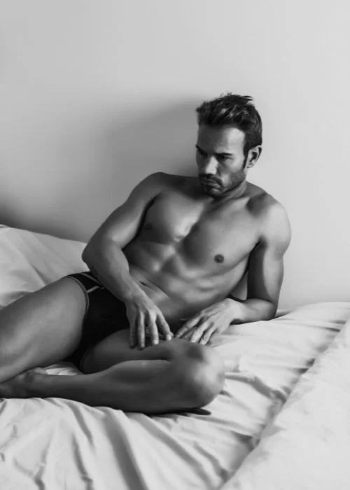 Relaxed men boudoir pose on bed creating a bold and intimate portrait mood