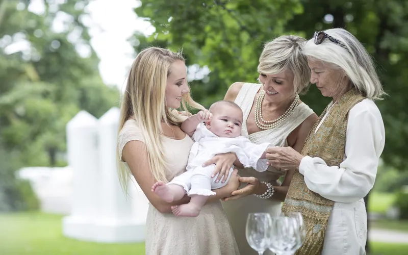 generations of family holding baby together
