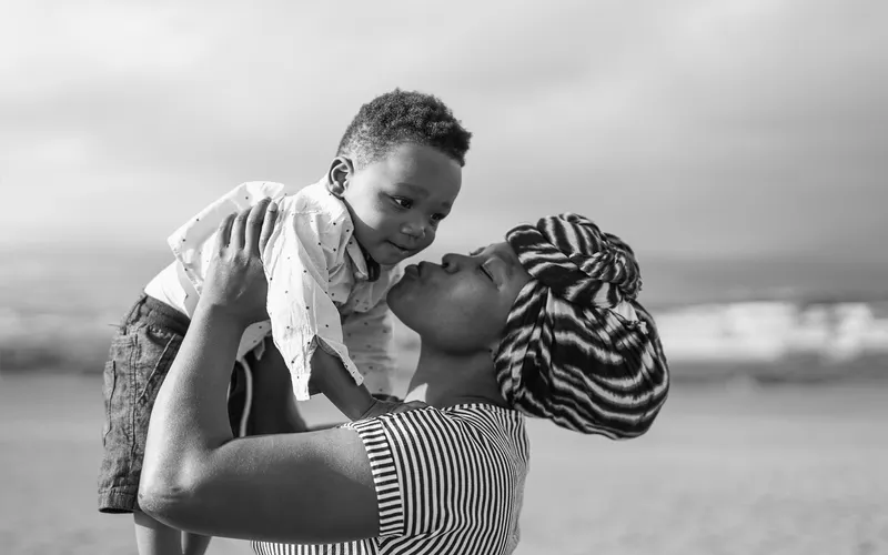 black and white photo of mom kissing son