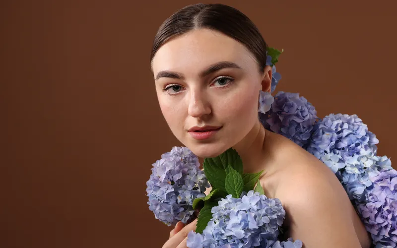 fine art portrait photography of a woman adorned with purple hydrangea flowers