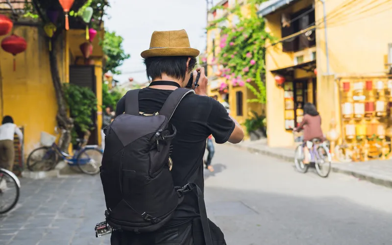 travel photographer taking photos of street on a sunny day