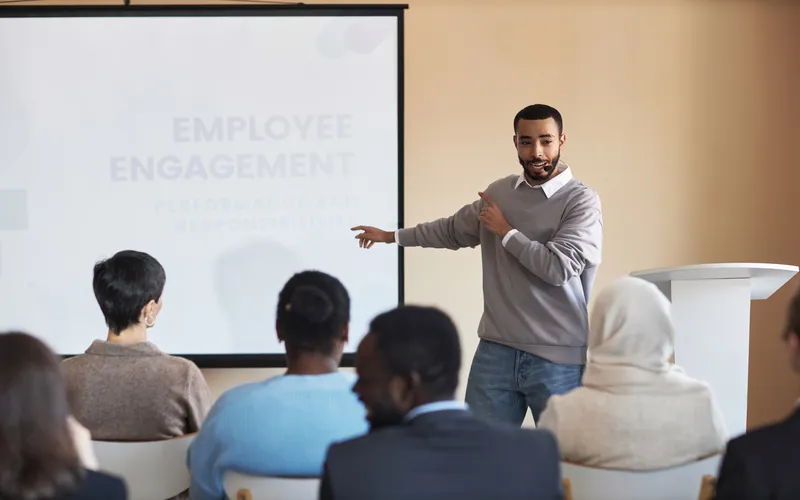 confident man giving business presentation in front of crowd