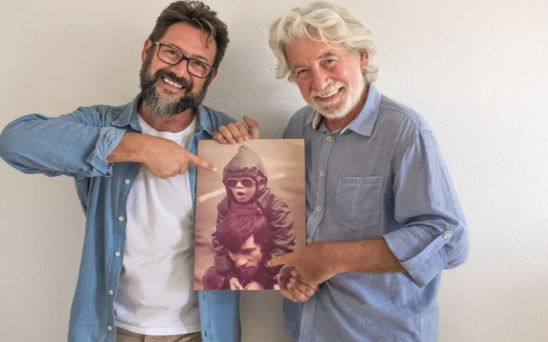 father and son holding their old photo