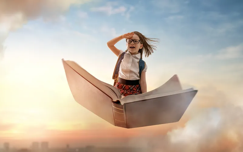 surreal levitation photography of a girl flying on a giant book