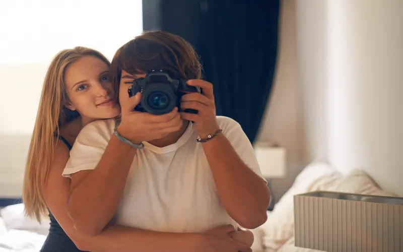 couple taking mirror selfie with camera