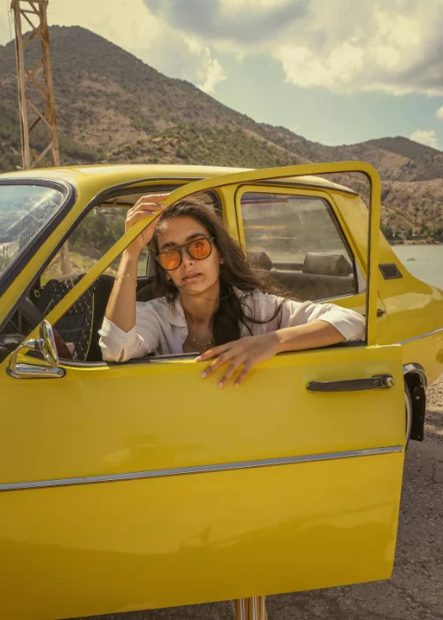 vintage car photoshoot ideas - a model posing on the window of a car