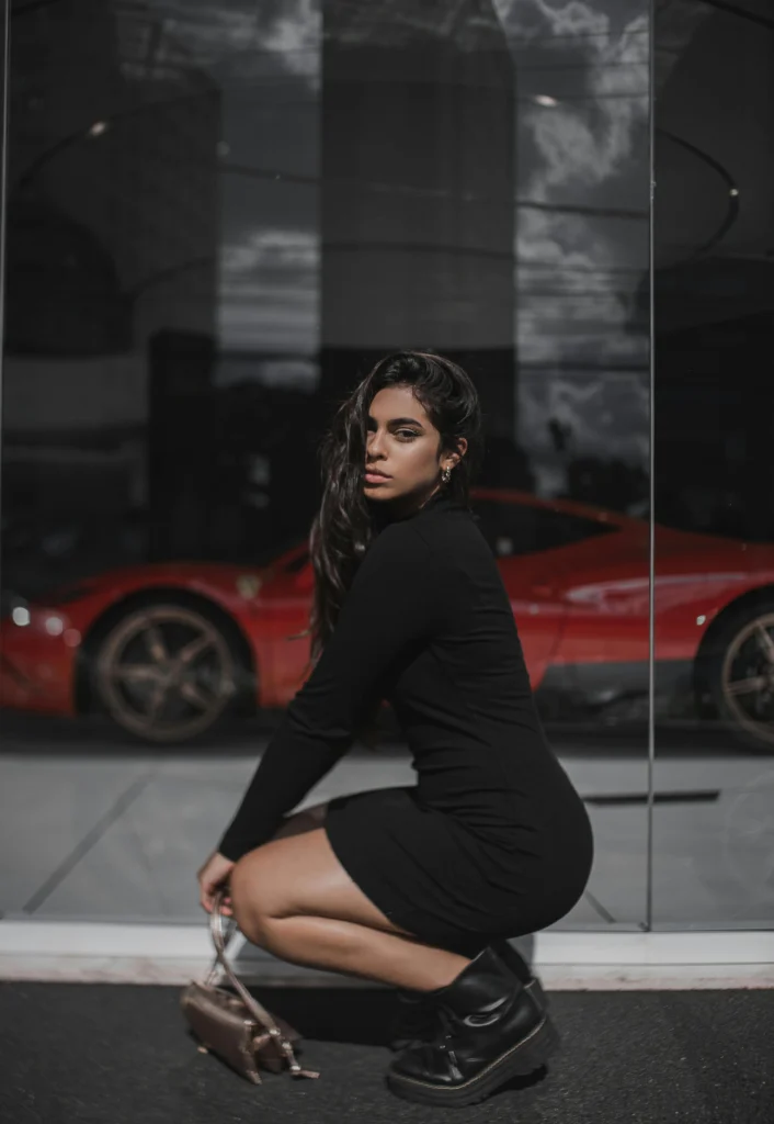 a model posing with the car in the background