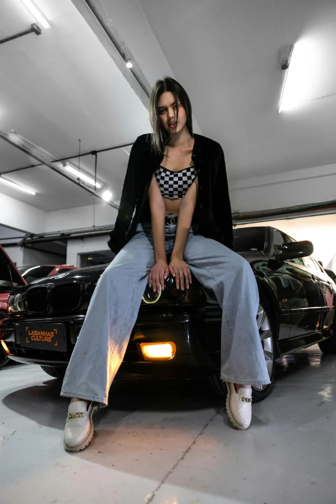 car photoshoot ideas - low angle of a model posing on the hood