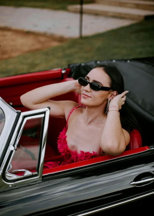 a model posing in a convertible