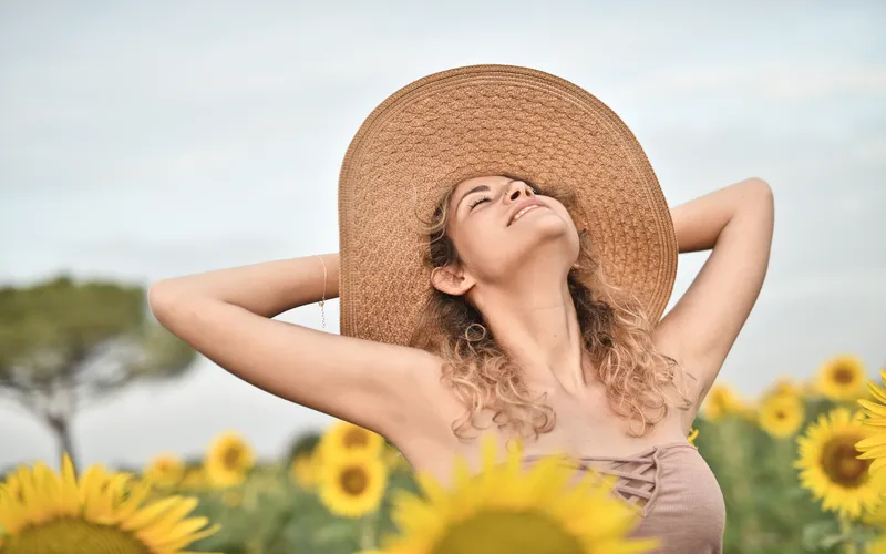 woman soaking up the sun in a sunflower field