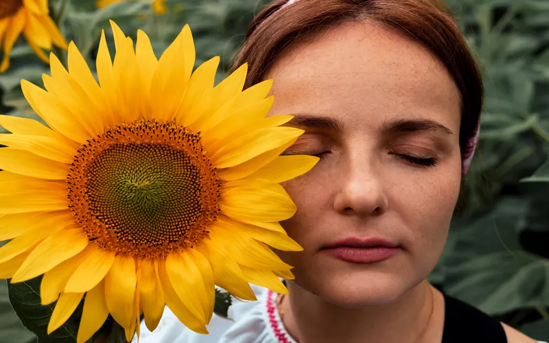 a woman posing with a sunflower for a portrait shot