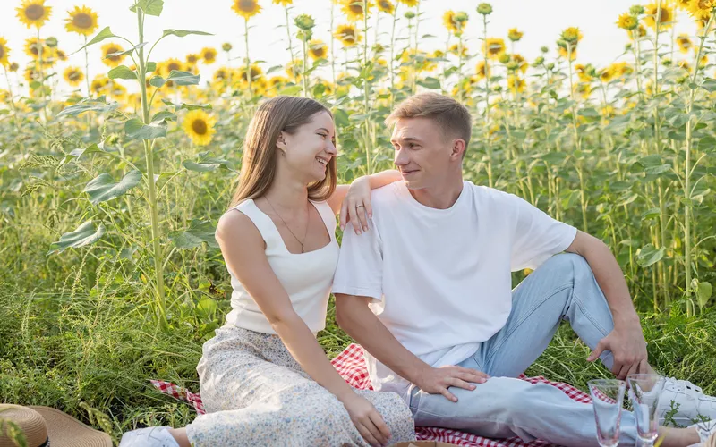 couple sitting in the sunflower field to pose for a photo