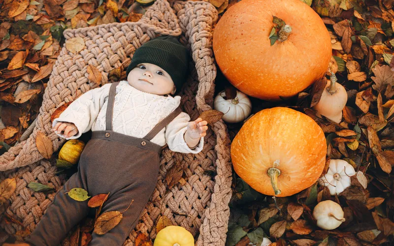 thanksgiving photoshoot of a baby with pumpkins
