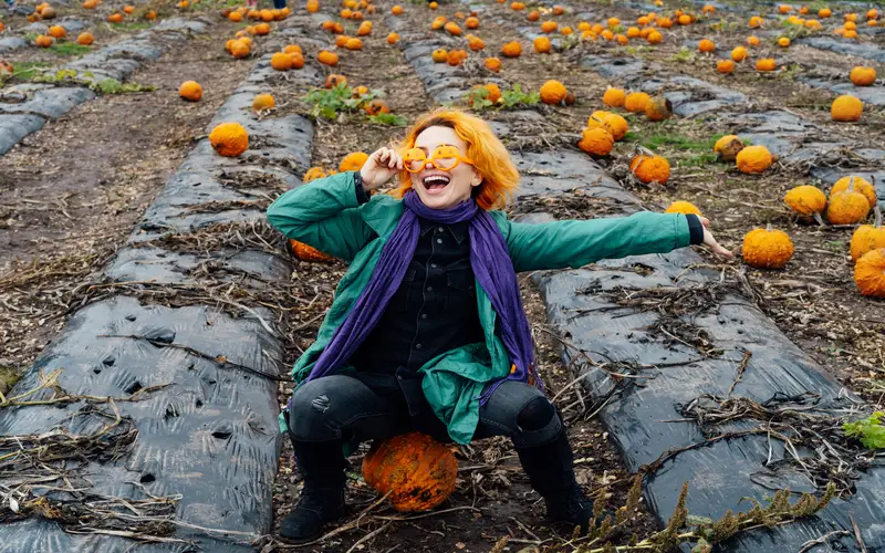 women posing for a photo in a pumpkin patch