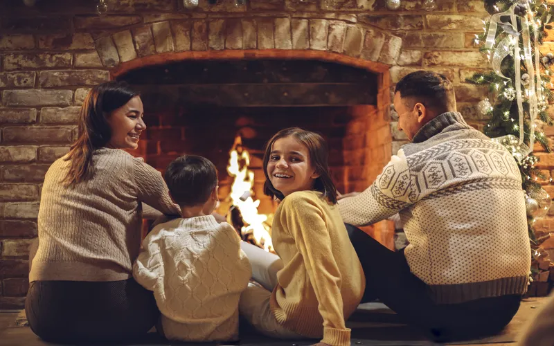 family enjoying holidays by the fireplace