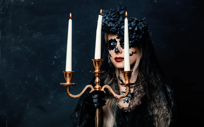 woman holding candle with day of the dead makeup