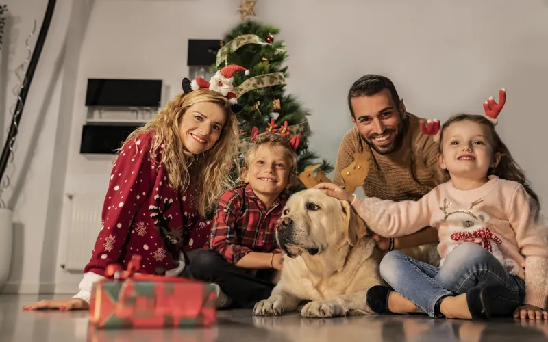 Photo of family and their pet celebrating Christmas celebration