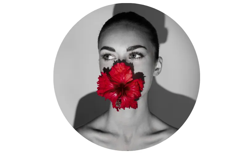 black and white instagram profile picture of a woman with red hibiscus flower covering her face