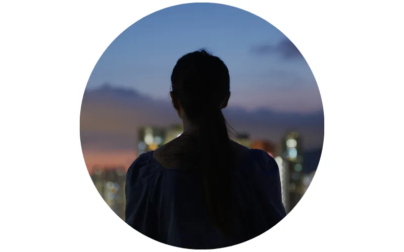 silhouette of a woman looking at city lights