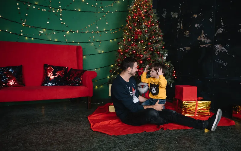 Candid photo of father and child near Christmas tree