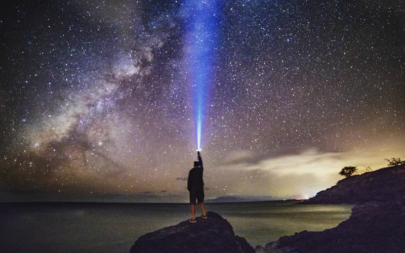 photo of night sky with a tourist looking at the stars