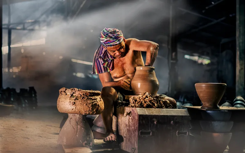 photo of a potter making clay pots
