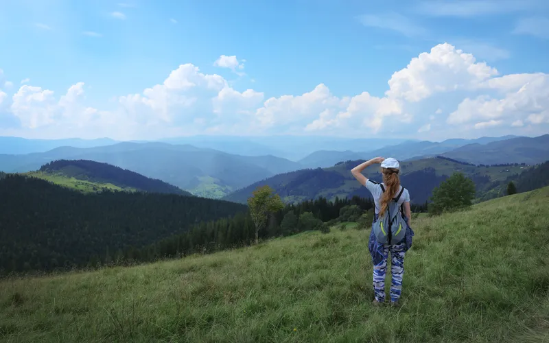 photo of a women in hiking gear against a beautiful landscape