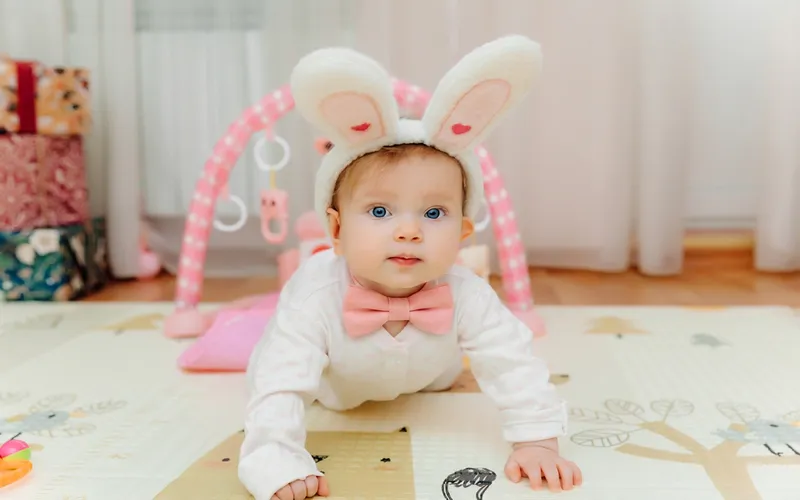 photo of a baby wearing bunny ears and bowtie, easter infant photo ideas for festive season