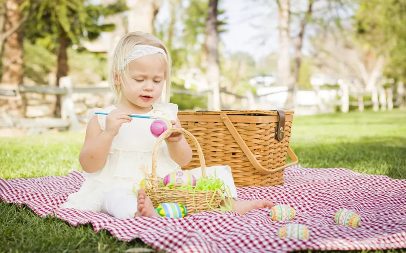 Girl hand painting easter eggs