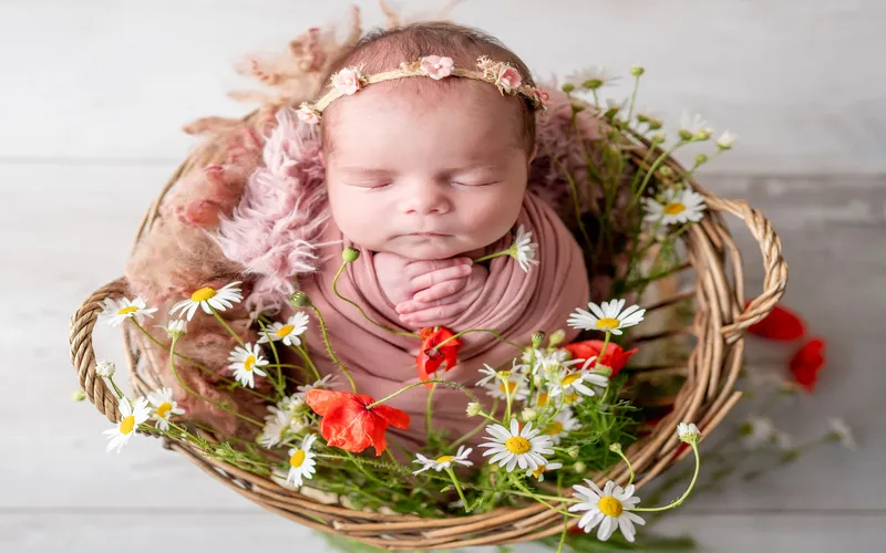 baby lying in the basket decorated with a seasonal wreath